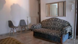 帕拉利亚狄奥尼索Maria Apartments的客厅配有椅子和镜子
