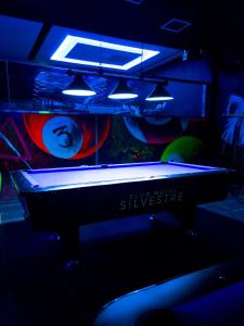 拉罗马纳Hotel Silvestre的黑暗的房间里设有一张台球桌,配有灯光
