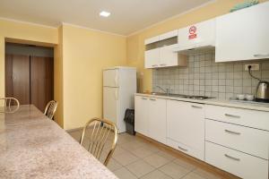 马里博尔Beg Rooms的厨房配有白色橱柜、桌子和冰箱。