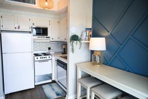 默特尔比奇HGTV Inspired Oceanfront Studio - Myrtle Beach Resort的厨房配有白色冰箱和桌椅