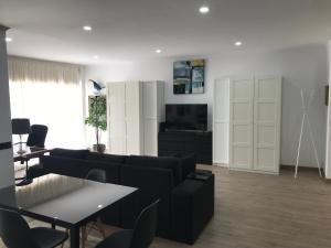 波尔蒂芒New Casa Praia da Rocha的客厅配有黑色沙发和桌子