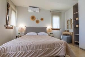 吉奥塔略Villa Sunrise的一间卧室配有一张大床,墙上有两盏灯