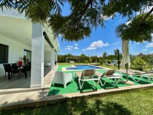 大桑卢卡尔OLE TÚ ANDALUCIA的后院设有游泳池、桌子和椅子