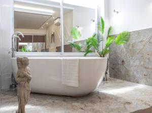 莱斯特The Pocklington - The Ceremonial Suite的带浴缸和雕像的浴室