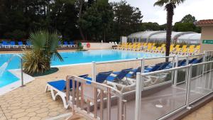 圣让-德蒙MH 127 Bois Dormant 3ch climatisé的游泳池旁设有蓝色和黄色的椅子