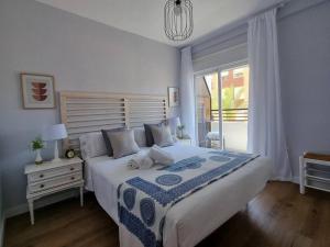阿瓜杜尔塞Aguadulce, Apto nuevo 2 hab con terraza, Aire, WiFi, a 5 min de la playa的一间卧室设有一张大床和一个窗户。