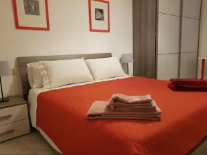 博洛尼亚Your Comfort Home - Bologna的一间卧室配有红色的床和毛巾