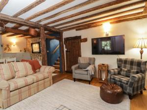 科姆堡Fox Den Cottage的客厅配有沙发、两把椅子和电视