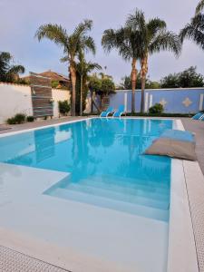 莫斯村B&B Villa Eraclea的棕榈树别墅内的游泳池