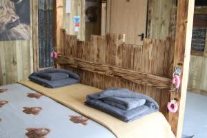 阿博伦The Moo-tel at Bargoed Farm的木制客房内的两张床和毛巾