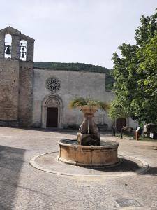 阿塞尔吉B&B La casa dei nonni Assergi的一座带教堂的建筑前方的大型喷泉