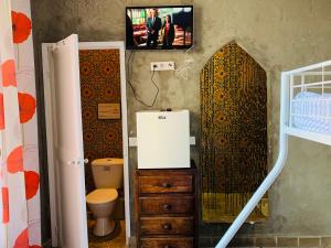 圣罗兰度瓦Laurentissime的一间带卫生间的浴室和墙上的电视