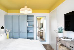 库克斯港Seehuus Duhnen Apartments的卧室设有白色的床和黄色的天花板