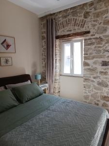 科孚镇Beau Maison的一间卧室设有一张床和石墙