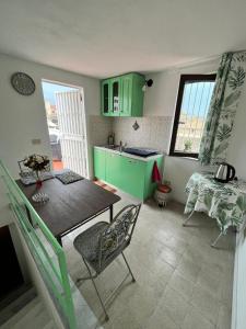 巴勒莫Mille Lire的厨房配有绿色橱柜和桌椅