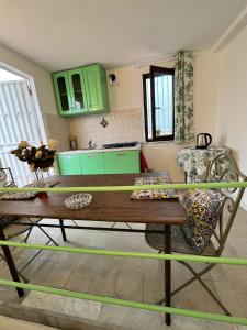 巴勒莫Mille Lire的厨房配有绿色橱柜和木桌