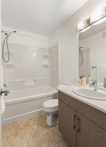 温尼伯Quiet, modern, stylish, one King & two Queen size beds, central location, parking的白色的浴室设有卫生间和水槽。