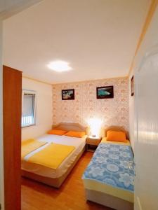 尤塔哈Apartmani LJUBICA的一间卧室设有两张床和一堵墙