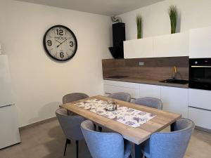 巴尔巴特纳拉布House Ema的一间设有桌子和墙上时钟的餐厅