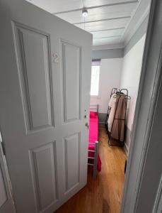 菲盖拉-达福什Casa Flamingo的一间房间,有白色的门和粉红色的手提箱