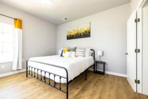 斯蒂芬维尔The Hive - Downtown Stephenville的卧室配有白色墙壁和木地板。