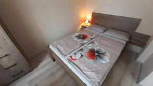 福纽德Vízparti nyaraló的一间卧室,床上放着两朵鲜花