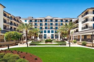 杰基尔岛The Westin Jekyll Island Beach Resort的一座大型公寓楼,拥有草坪和棕榈树