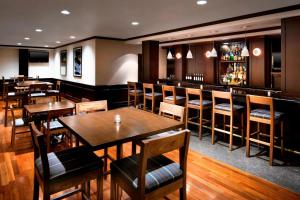 桑兹顿里士满机场福朋喜来登酒店的一间带桌椅的餐厅和一间酒吧