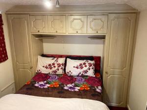 利兹Harman Suites Self-Catering Apartments Free WIFI & Parking的一个小房间的床,上面有鲜花