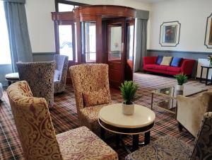 瑟索Royal Thurso Hotel的客厅配有椅子、桌子和沙发