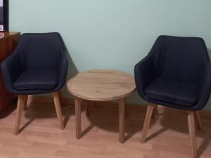 波尔托罗Apartments & Rooms Karmen的客房内的2把蓝色椅子和1张木桌