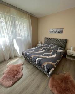 查查克Apartman Smile的卧室配有一张床,地板上铺有2个地毯。