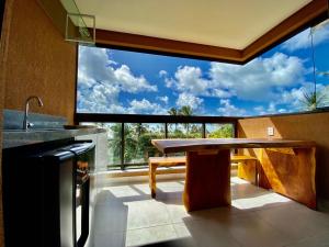 塔曼达雷Flat luxo 04 torre 06 Eco Resort Carneiros的厨房配有桌子和大窗户