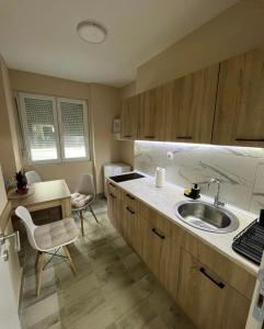 查查克Apartman Smile的厨房配有水槽和桌椅