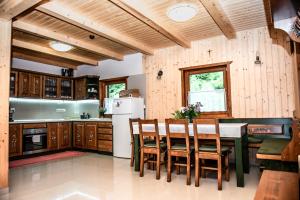 VărşagCentral Chalet的厨房配有木制橱柜和桌椅