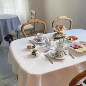 SauvoVinter Bed & Breakfast的一张白色桌子,上面有杯子和盘子
