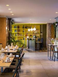 巴黎加斯顿酒店的一间带木桌和椅子以及黄色架子的餐厅