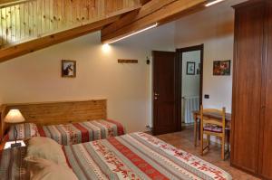 BionazAppartamenti Luseney的一间卧室设有两张床和木制楼梯。