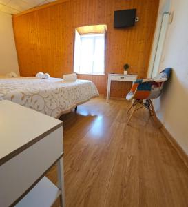 埃尔瓦斯Alcamim Guesthouse的一间卧室设有两张床、一张桌子和一个窗口。