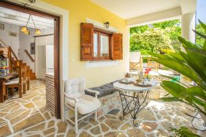 SívrosTraditional family villa southern lefkada的客房设有带桌椅的庭院。
