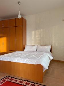 克鲁亚Vila 8 Kruje的一间卧室配有一张大木床和白色床单