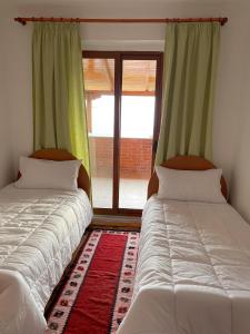 克鲁亚Vila 8 Kruje的两张床位于带窗户的房间内