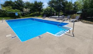 米德尔敦Red Roof Inn & Suites Newport - Middletown, RI的旁边设有2把椅子的大型游泳池