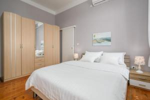 奥帕提亚Apartment Gloria的卧室配有一张白色大床和木制橱柜。