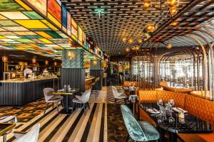 阿姆斯特丹Apollo Hotel Amsterdam, a Tribute Portfolio Hotel的餐厅拥有色彩缤纷的天花板和桌椅