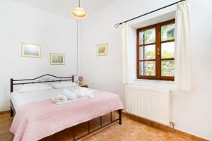 帕纳基雅Villa Nina的一间卧室配有一张带粉色毯子的床和窗户。