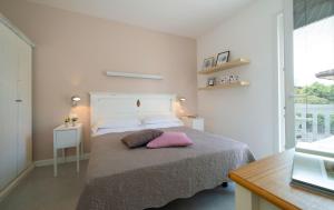 比比翁Nice Hotel Bibione的一间卧室配有一张带粉红色枕头的床