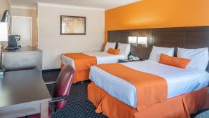 北湾Knights Inn North Bay的酒店客房,设有两张带橙色墙壁的床