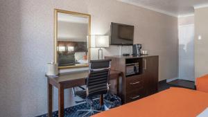 北湾Knights Inn North Bay的酒店客房配有书桌和镜子