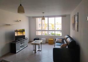 El Morro de BarcelonaConfortable apartamento en Marina del Rey Lecheria的客厅配有沙发和桌子